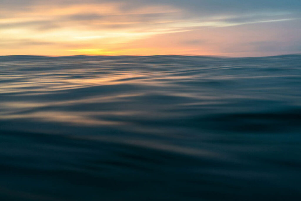 In the middle of the ocean during sunset.